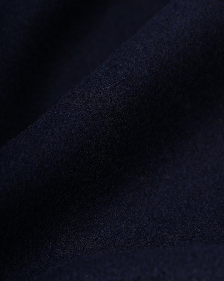 Close-up of dark navy blue wool from the EFF Detroit Tigers 1955 Authentic Wool & Leather Varsity Jacket, highlighting its soft, slightly fuzzy texture and gentle folds.