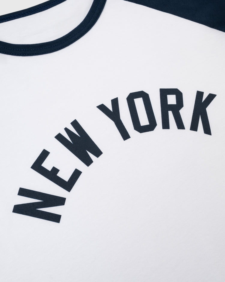 Close-up of the Ebbets Field New York Black Yankees Vintage Baseball Tee, a white tee with black trim featuring bold, arched NEW YORK lettering—a tribute to the legendary Negro National League team.