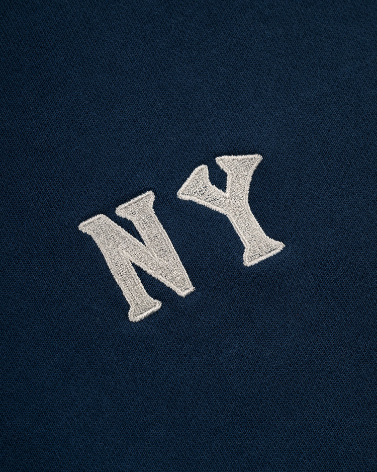 White NY embroidery stands out on dark blue heavyweight cotton terry—classic Ebbets Field style. This New York Black Yankees Pullover Hoodie is inspired by Negro Leagues apparel for an iconic look up close.