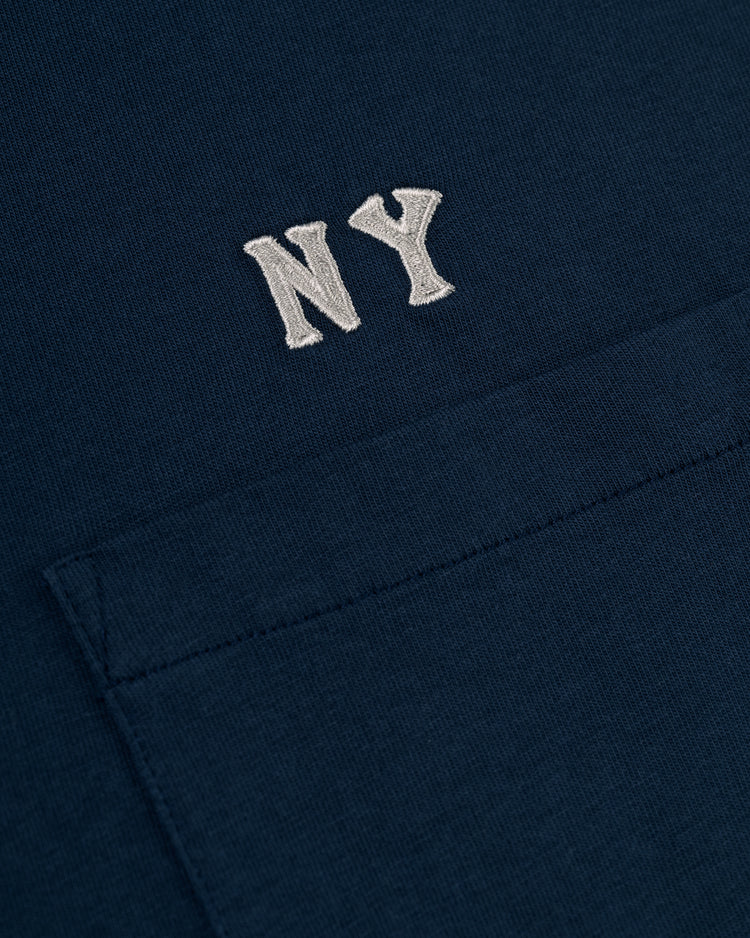Close-up of the Ebbets Field New York Black Yankees Embroidered NY Long Sleeve Pocket Tee, a dark blue shirt with white NY above the pocket, inspired by classic Negro League uniforms.