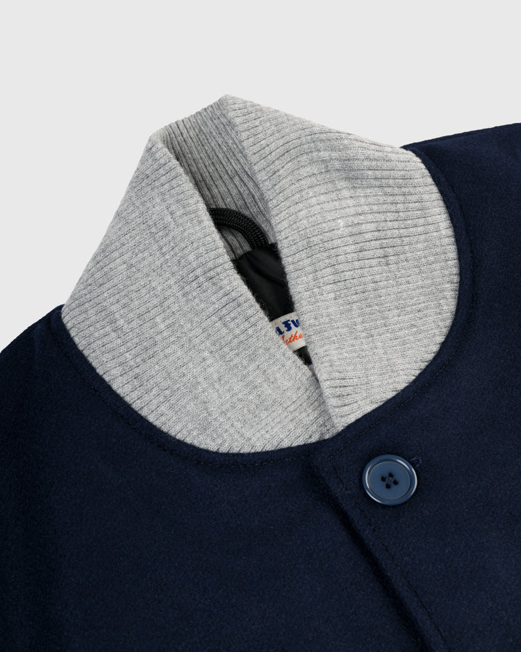Close-up of the EFF New York Yankees 1936 Authentic All Wool Varsity Jacket in navy blue with a gray ribbed collar, dark blue button, and partially visible label—a faithful reproduction of the classic on-field jacket.