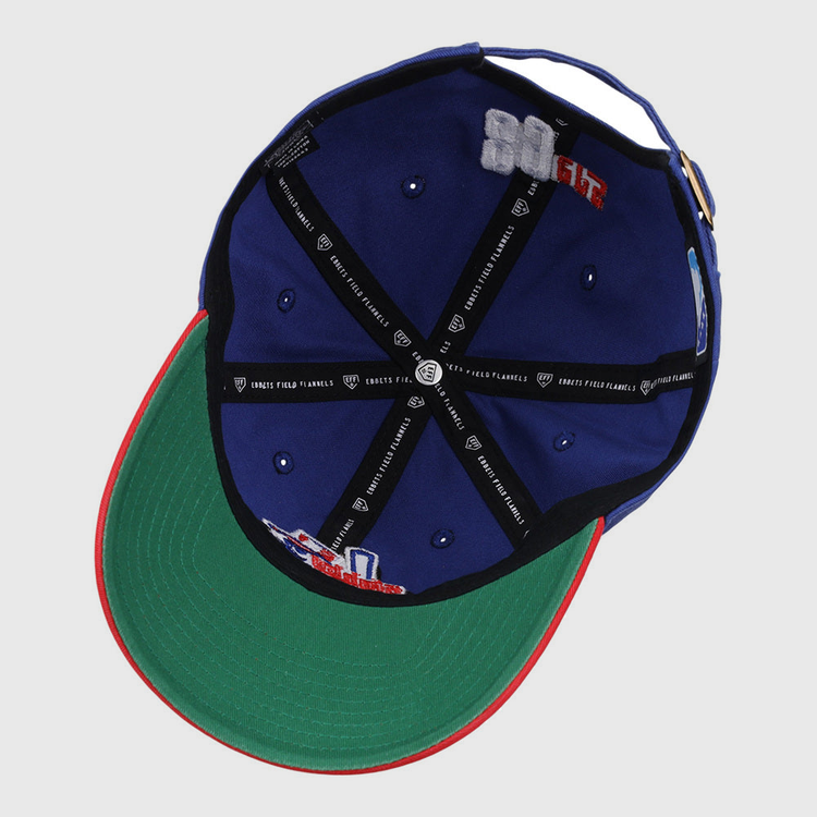 The Ebbets Field Oklahoma City 89Ers MiLB Logo Dad Ballcap is blue, with a green underbrim, red edge, black inner seams with white text, and embroidered interior patches.
