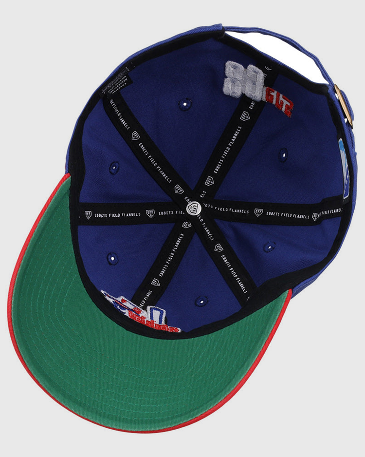 The Ebbets Field Oklahoma City 89Ers MiLB Logo Dad Ballcap is blue, with a green underbrim, red edge, black inner seams with white text, and embroidered interior patches.