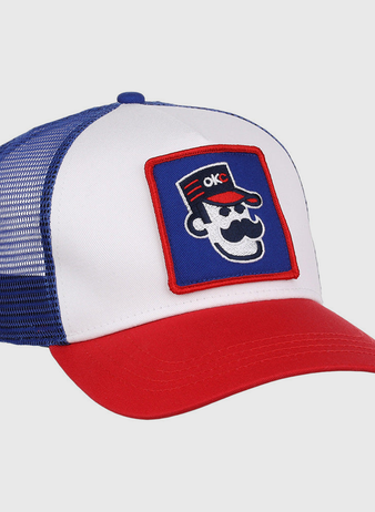 The Ebbets Field Oklahoma City 89Ers MiLB Trucker Ballcap features a white front panel, blue mesh back, red brim, and a patch of a cartoon face with sunglasses, mustache, red hat, and OKC letters.