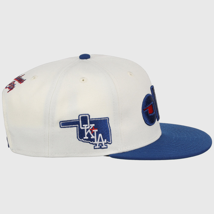 The Ebbets Field Oklahoma City Dodgers MiLB Snapback Ballcap is a white cap with a blue brim, side embroidery of Oklahoma with 