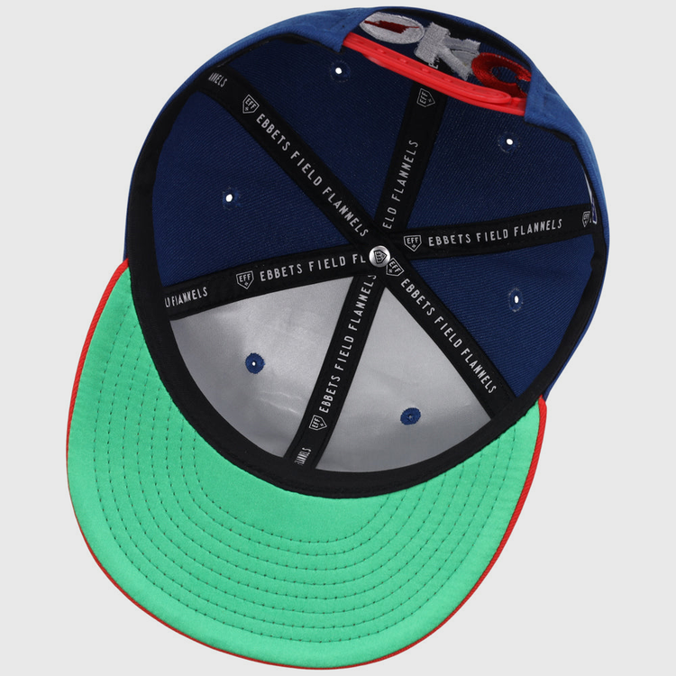 The underside of the Oklahoma City Dodgers MiLB Two Tone Snapback Ballcap by Ebbets Field features a green brim, black inner seams labeled EBBETS FIELD FLANNELS, blue inner panels, and a red edge around the brim.