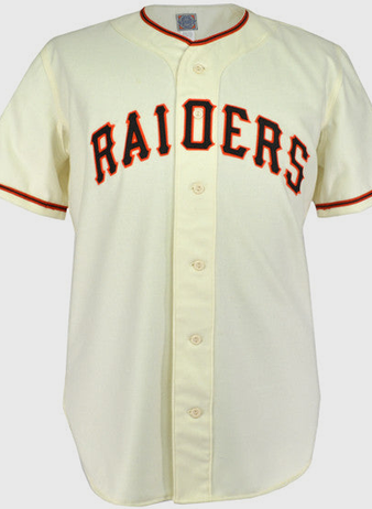 The EFF Pauls Valley Raiders 1954 Home Jersey is a cream baseball jersey with black and orange trim, featuring RAIDERS in bold black letters with orange outline across the chest, honoring the Sooner State League team.