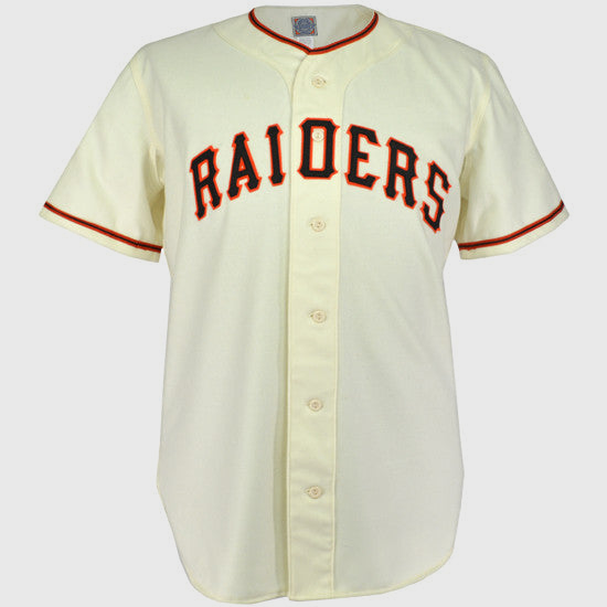The EFF Pauls Valley Raiders 1954 Home Jersey is a cream baseball jersey with black and orange trim, featuring RAIDERS in bold black letters with orange outline across the chest, honoring the Sooner State League team.