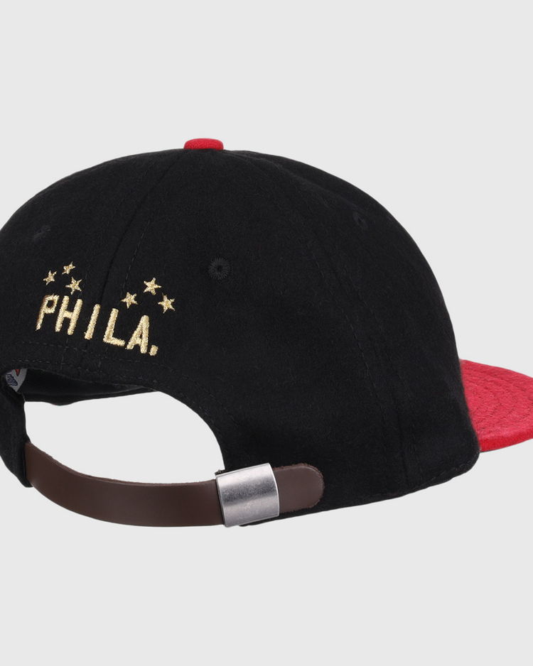 The EFF Philadelphia Stars Gilded Collection Ballcap is a vintage-style hat with a red brim and adjustable brown strap. PHILA. and five gold stars, honoring the Negro National League, are embroidered above the clasp.