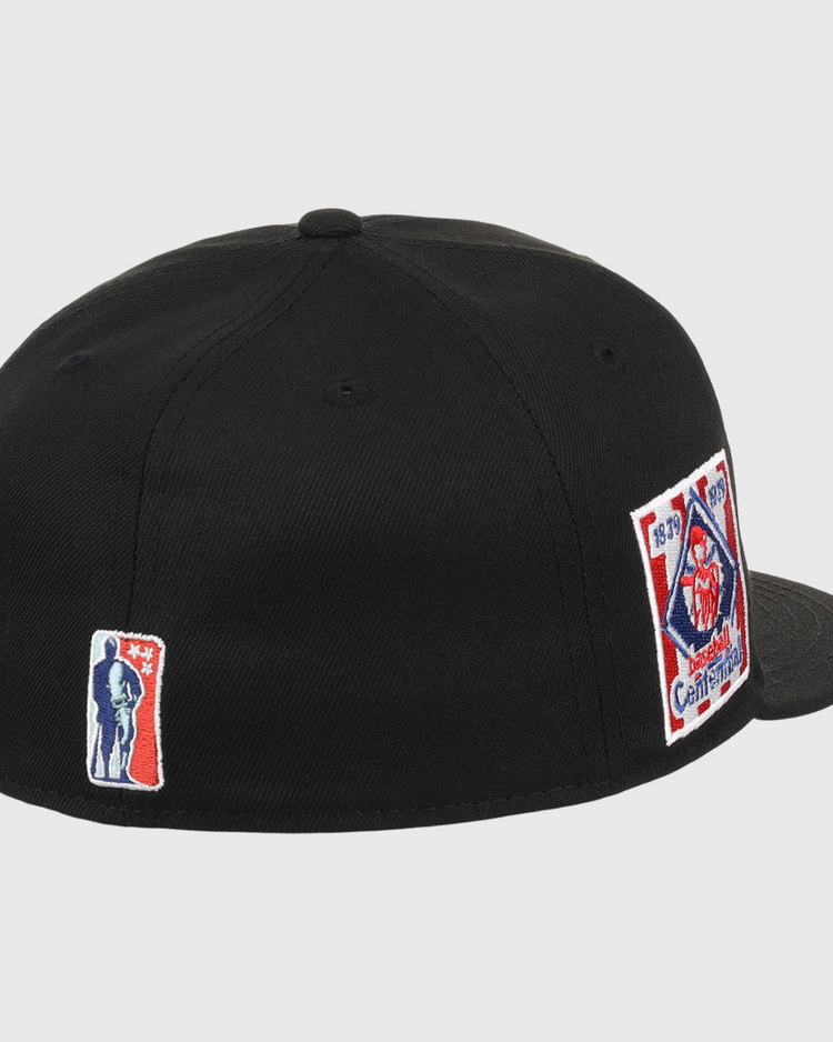 The EFF Philadelphia Stars NLB Team Color Fitted Ballcap is a black cap featuring a rectangular fire department emblem patch with red, white, and blue details on the side and an embroidered Star logo patch on the back.