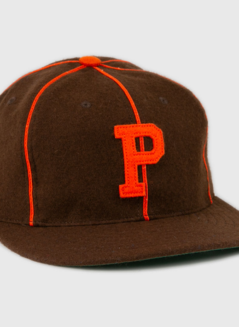 The EFF Pocatello Bannocks 1952 Vintage Ballcap is a brown wool baseball hat with orange piping, an orange top button, and a large orange “P” embroidered on the front.