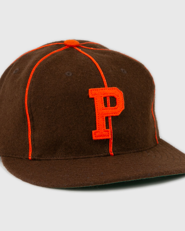The EFF Pocatello Bannocks 1952 Vintage Ballcap is a brown wool baseball hat with orange piping, an orange top button, and a large orange “P” embroidered on the front.