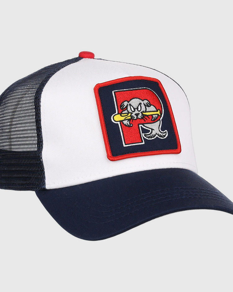The Ebbets Field Portland Sea Dogs MiLB Trucker Ballcap features a white front, navy blue bill and mesh back, plus a patch with a stylized fish holding a bat inside a red-bordered 