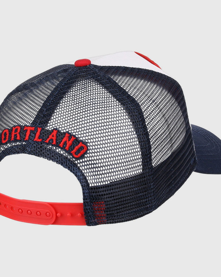 The Ebbets Field Portland Sea Dogs MiLB Trucker Ballcap is a navy blue mesh hat with a red adjustable snapback and PORTLAND embroidered in red above the back opening.