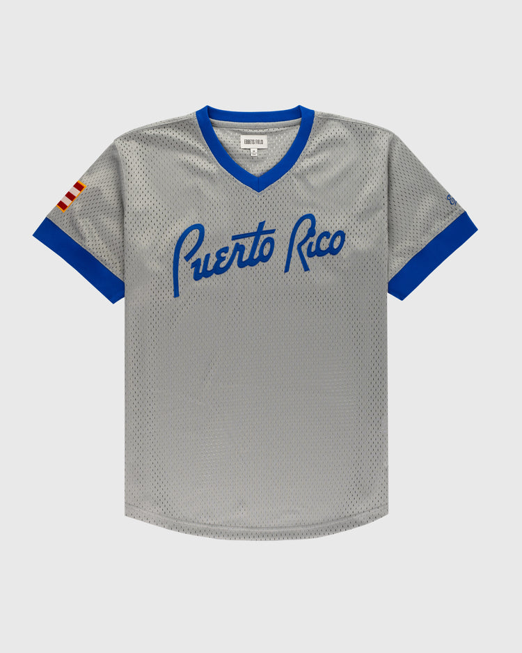 The Ebbets Field Puerto Rico 1958 National Team Mesh V-Neck Jersey features gray mesh, blue trim, Puerto Rico in blue script across the chest, and a red-and-white striped sleeve patch—a classic Puerto Rican baseball jersey.