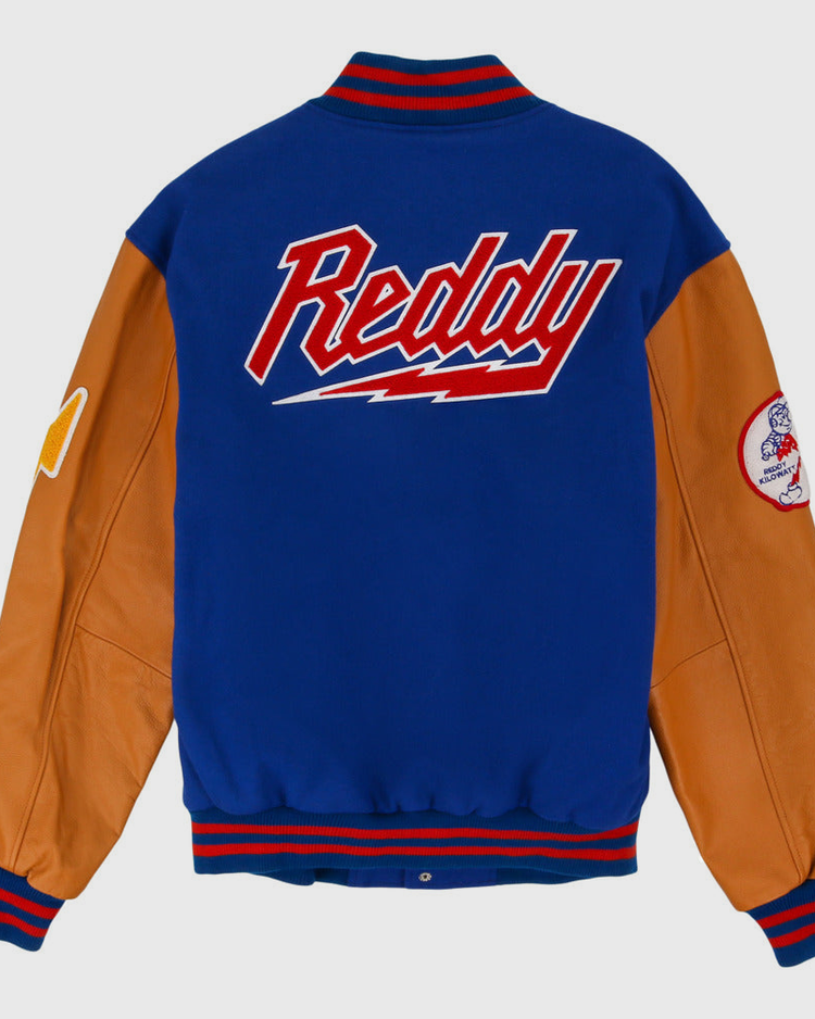 The Reddy Kilowatt DNA Varsity Jacket by Ebbets Field features a blue wool body, tan leather sleeves, red and blue striped cuffs, 