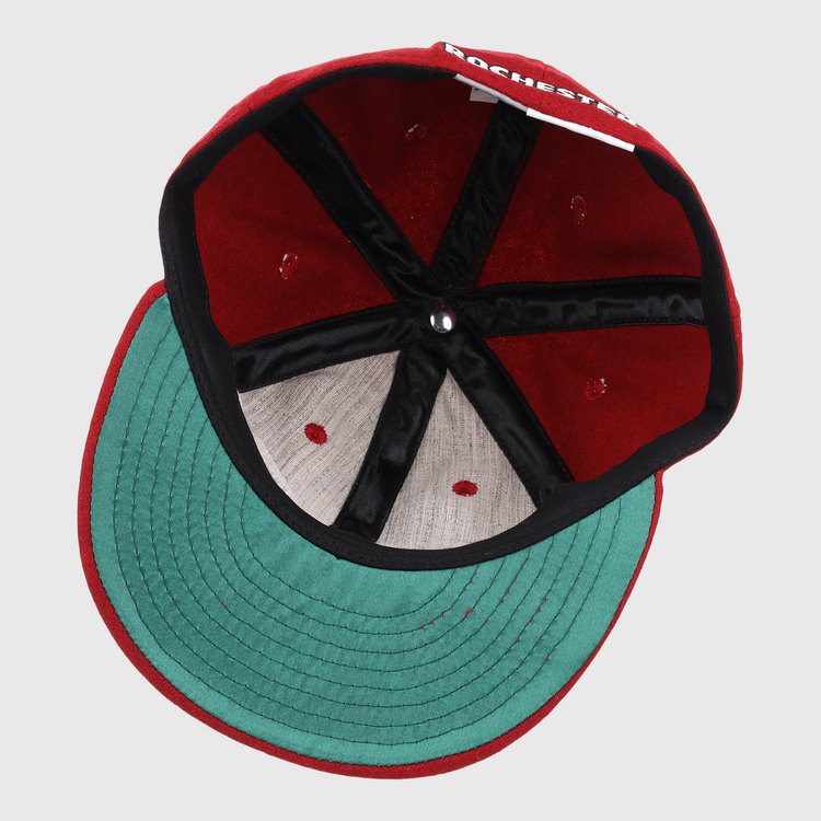An overhead look at the Rochester Red Wings Letterhead Wool Vintage Ballcap by EFF shows the red caps green underbrim, black seam lining, and part of ROCHESTER visible on the inner label.
