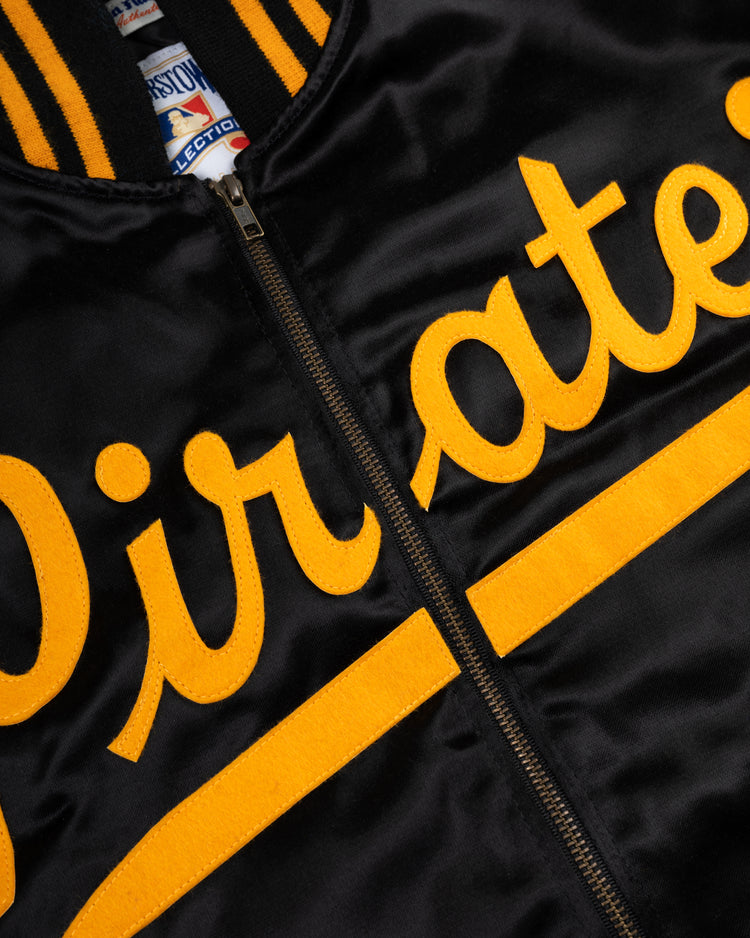 Close-up of the EFF Roberto Clemente 1970 Authentic All Satin Varsity Jacket in black with yellow Pirates script, zipper, striped collar, and Cooperstown Collection inner tag.