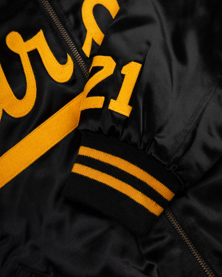 Close-up of the EFF Roberto Clemente 1970 Authentic All Satin Varsity Jacket in black with yellow felt letters, number 21 on the sleeve, and black-and-yellow striped ribbed cuff.