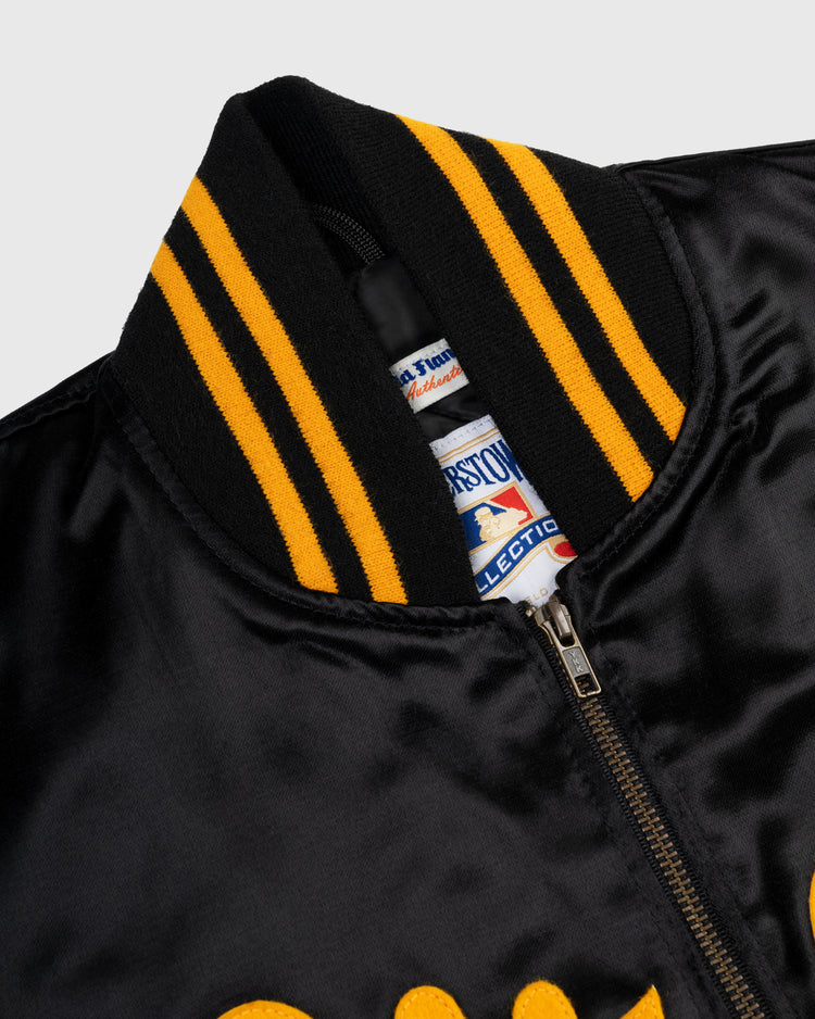 Close-up of the EFF Roberto Clemente 1970 Authentic All Satin Varsity Jacket in black, featuring a black and yellow striped ribbed collar, visible zipper, interior tags, and part of a yellow script logo on the front.