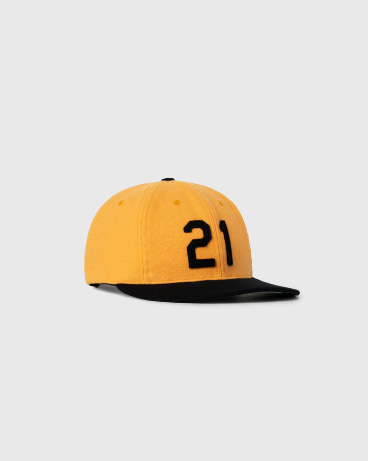 The Ebbets Field Flannels Roberto Clemente 1972 Signature Series Wool Ballcap is yellow with a black brim and features the number 21 in black on the front, honoring Clemente, shown on a plain light gray background.