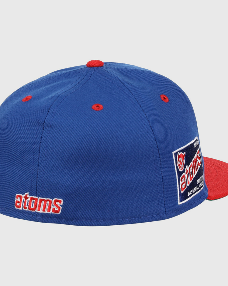 The Sankei Atoms EFF DNA Fitted Ballcap by EFF features blue vintage styling with a red button and brim, atoms embroidered in red and white on the side, an atoms logo patch on the back, and classic Ebbets Field Flannels craftsmanship.