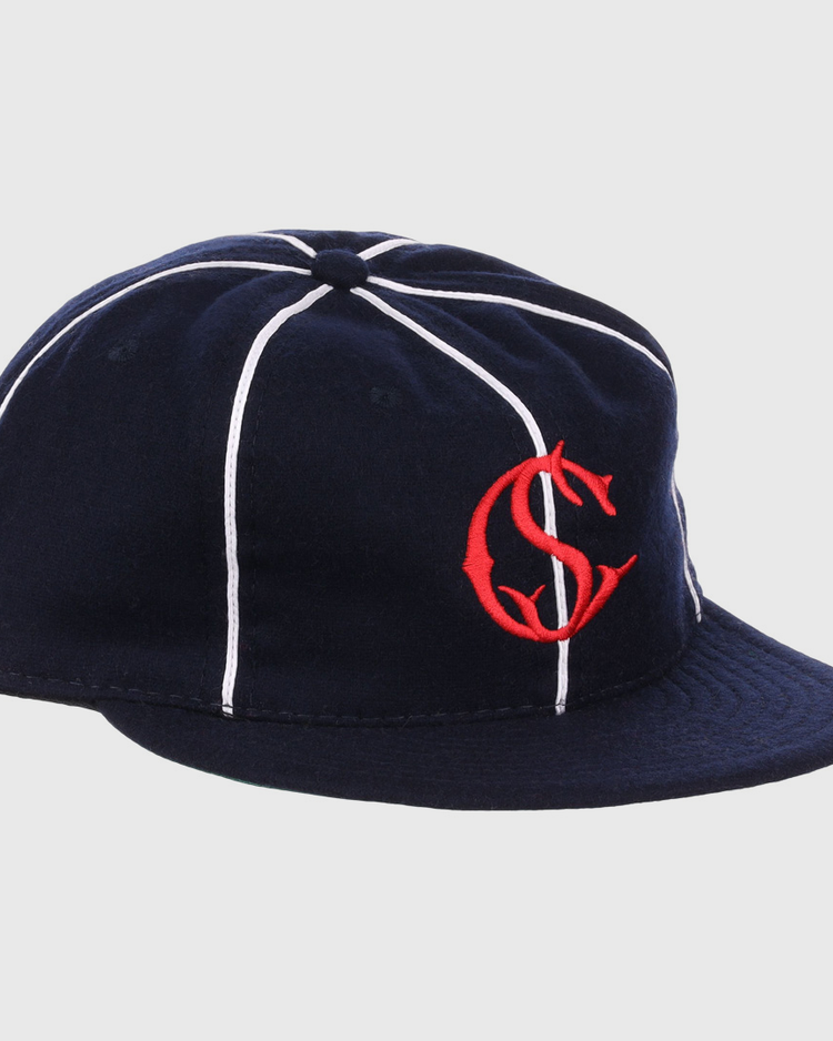The EFF Santa Cruz Crabs 1908 Vintage Ballcap features navy blue wool with white stripes and a red interlocking “C” and “S” logo on the front, offering a timeless, classic baseball style.