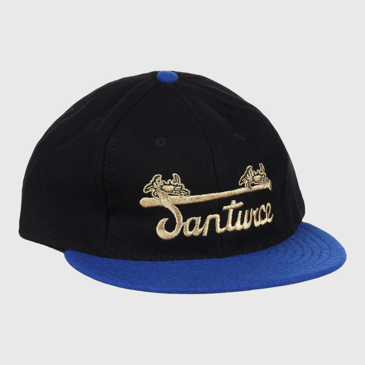 The EFF Santurce Cangrejeros Gilded Collection Ballcap features a black crown, blue brim, gold scroll details, and Santwoz gold script embroidery—a striking nod to the Puerto Rico League.