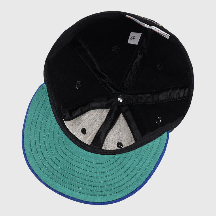 A top-down view of the EFF Santurce Cangrejeros Gilded Collection Ballcap, showing its black design, green visor, blue trim, visible stitching, sweatband, size tag, and interior lining.