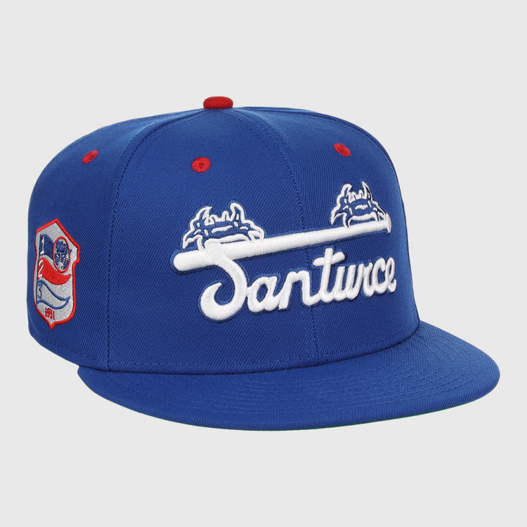 The EFF Santurce Cangrejeros NLB Team Color Fitted Ballcap is a vintage-inspired blue hat with Santurce in white under two blue and white crab logos, plus a Puerto Rican League red and white side patch and red accents on the top and eyelets.