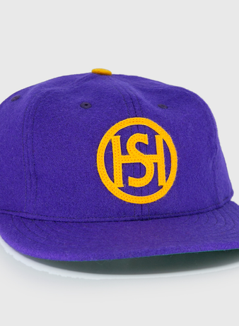 The EFF Spokane Canaries 1917 Vintage Ballcap is a purple wool cap with a yellow embroidered circular ISH logo, Pacific Coast Hockey Association-inspired yellow side lettering, and an adjustable leather strap for comfort.