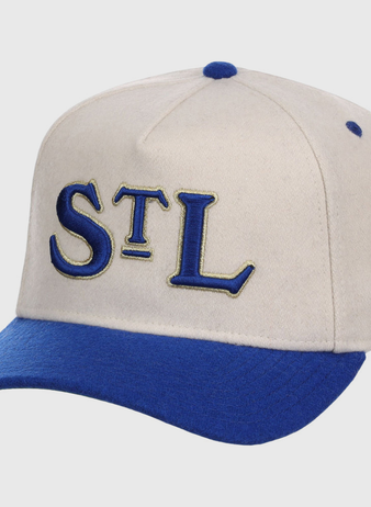 The Ebbets Field St. Louis Stars NLB Ballpark A-Frame Ballcap is beige with a royal blue brim and top button, featuring “STL” embroidered in blue and gold on the front.