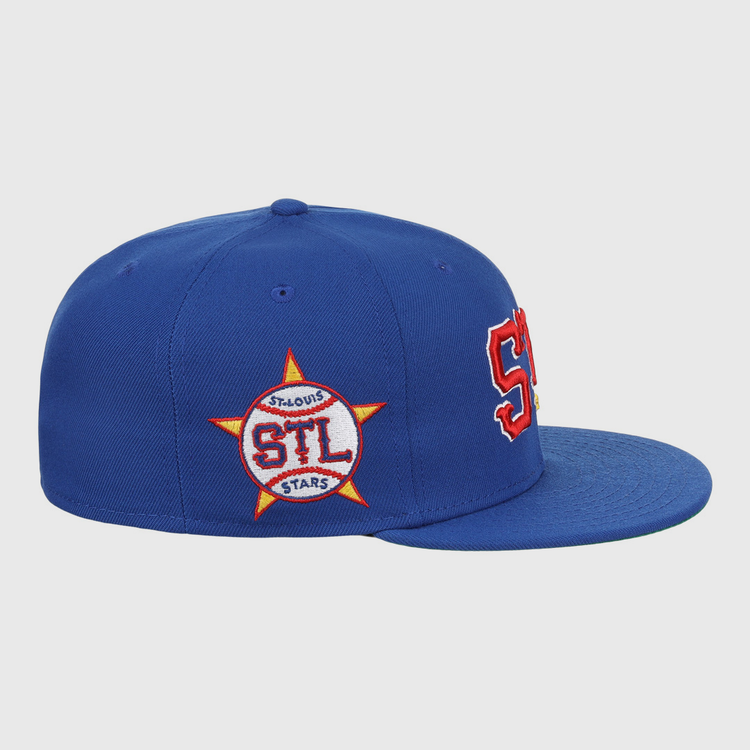 The EFF St. Louis Stars NLB Team Color Fitted Ballcap features a royal blue vintage style, bold red and white STL letters on the front, and a side star patch with STL ST. LOUIS STARS in red and white.
