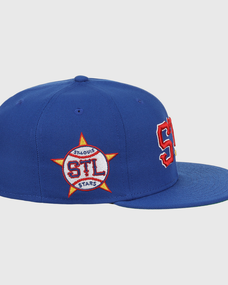 The EFF St. Louis Stars NLB Team Color Fitted Ballcap features a royal blue vintage style, bold red and white STL letters on the front, and a side star patch with STL ST. LOUIS STARS in red and white.