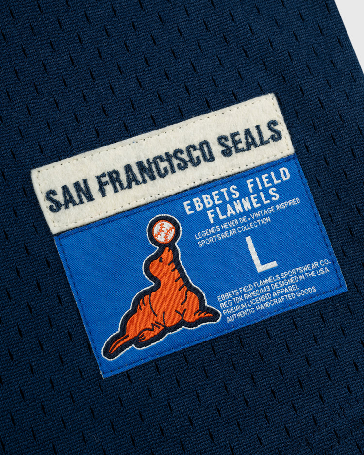 A blue patch on the San Francisco Seals Mesh V-Neck Jersey by EFF shows an orange seal balancing a baseball under “San Francisco Seals,” evoking vintage baseball style and classic EFF sportswear.