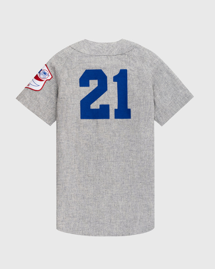 The Ebbets Field Santurce Cangrejeros 1954 Authentic Wool Road Baseball Jersey is gray with short sleeves, blue number 21 on the back, and a red, white, and blue patch on the left sleeve.