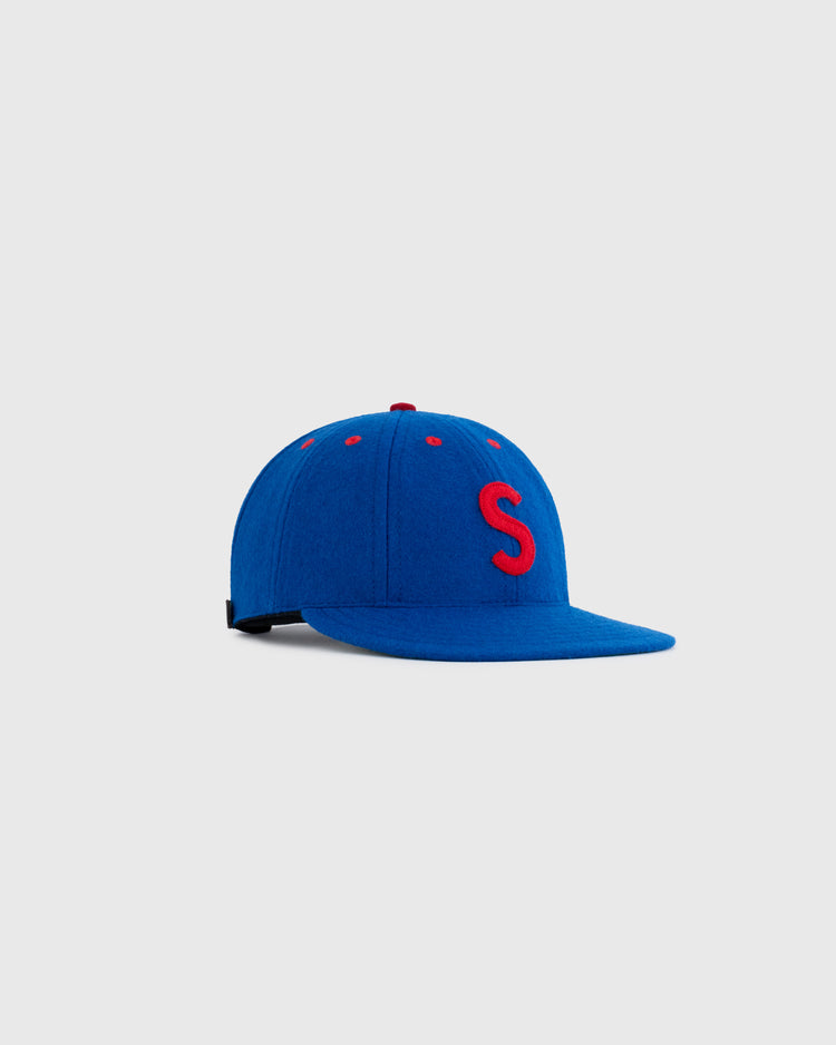 The EFF Seattle Rainiers 1938 Authentic 8-Panel Wool Ballcap features blue wool, a red embroidered S on the front, red top accents, and is shown on a plain light gray background.