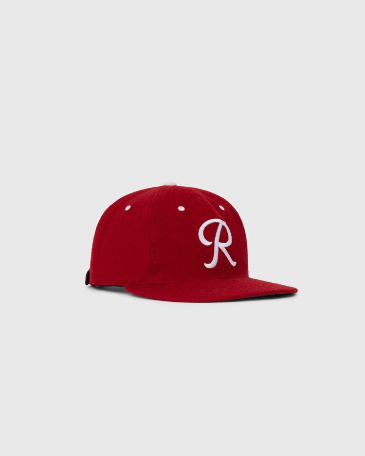 The EFF Seattle Rainiers 1955 Authentic Wool Ballcap features a red flat brim and a white embroidered R on the front, displayed against a plain light gray background.