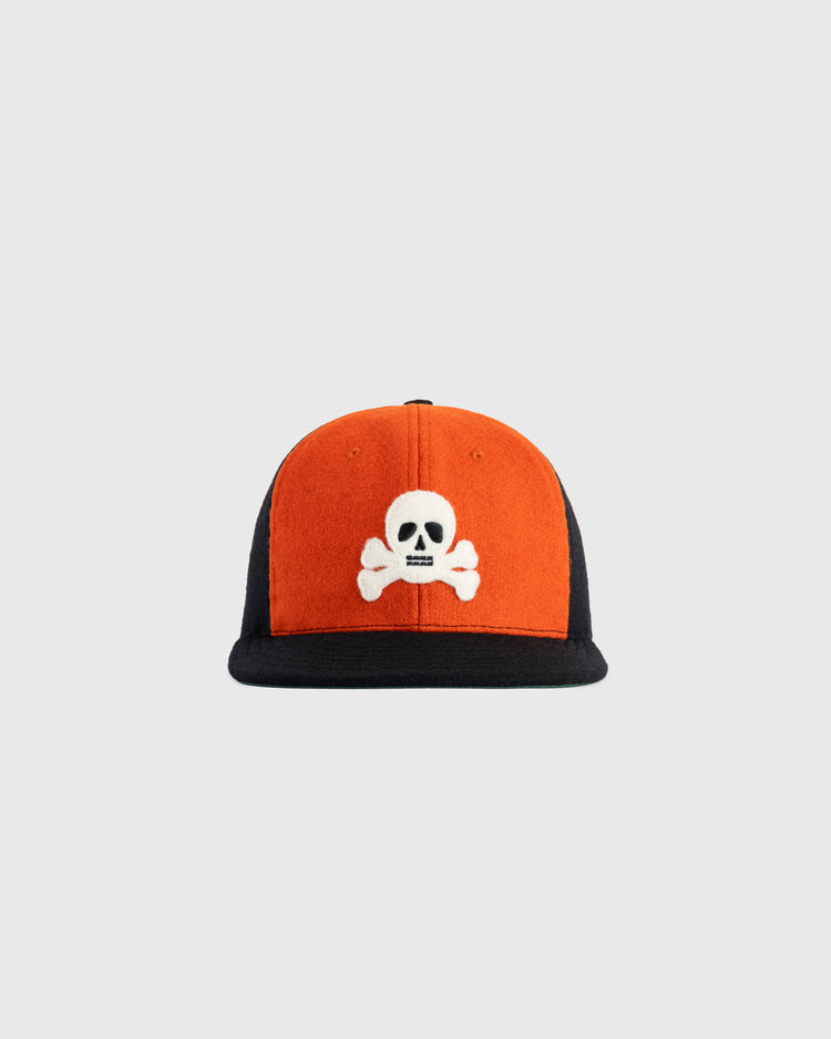 The EFF Sioux City Ghosts 1935 Authentic Wool Softbrim Ballcap features an orange front, black sides and brim, and a white skull and crossbones embroidered on the front, inspired by the legendary Negro League teams design.