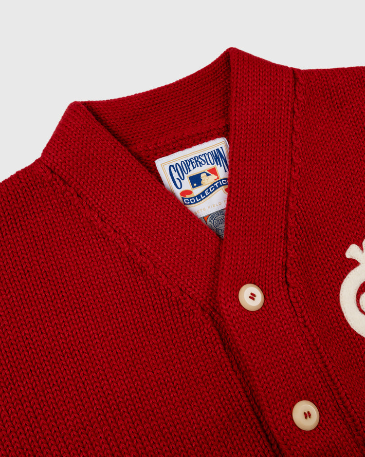 Close-up of the EFF St. Louis Cardinals 1908 Wool Shawl Collar Sweater, featuring cream buttons, a Cooperstown Collection label inside the collar, and a white embroidered applique on the right side.