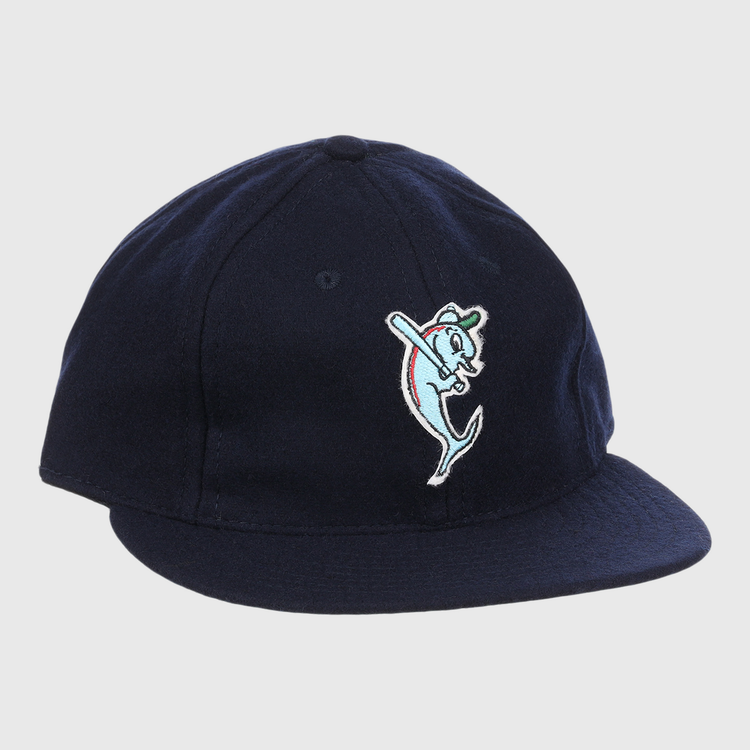 The EFF Tampa Tarpons Letterhead Wool Vintage Ballcap is a navy blue cap with a cartoon dolphin mascot in a green cap and red bat, inspired by Minor League baseball and the playful spirit of the Tampa Tarpons.