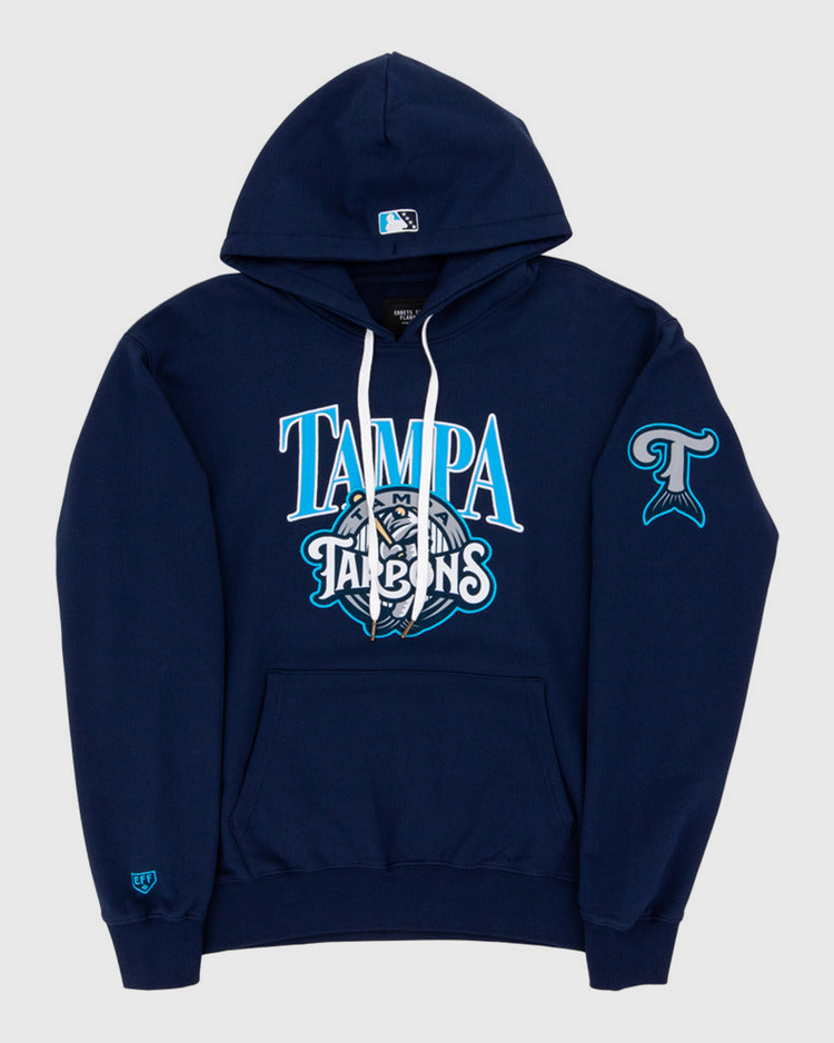 The Ebbets Field Tampa Tarpoons MiLB Cotton Hooded Sweatshirt features TAMPA TARPONS text and mascot logo on the chest, a fish tail logo on the left sleeve, a small logo on the right wrist, white drawstrings, and a front pocket.