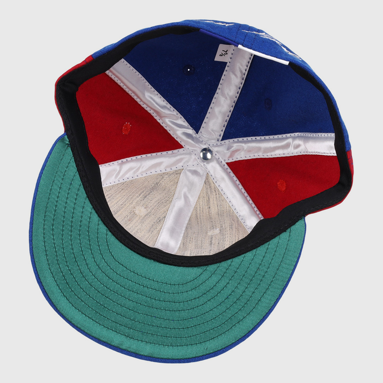The inside of the Ebbets Field Flannels Tim Raines Signature Series Ballcap features green underbill, red and blue panels, white stitching, a silver crown button, and a visible size tag.