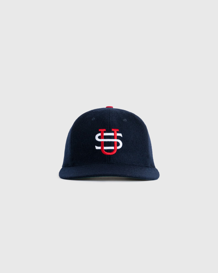 The EFF US Tour Of Japan 1934 Authentic Wool Ballcap features a navy blue color and a red and white interlocking US logo, echoing the classic Babe Ruth era style, shown on a plain light gray background.