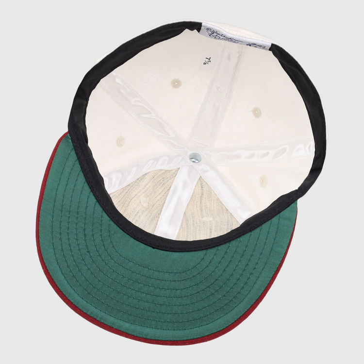 The image shows the inside of the EFF University of Alabama 1950 Vintage Ballcap, featuring a green brim with red edge, white interior panels, black lining, visible size label, and detailed top button stitching.
