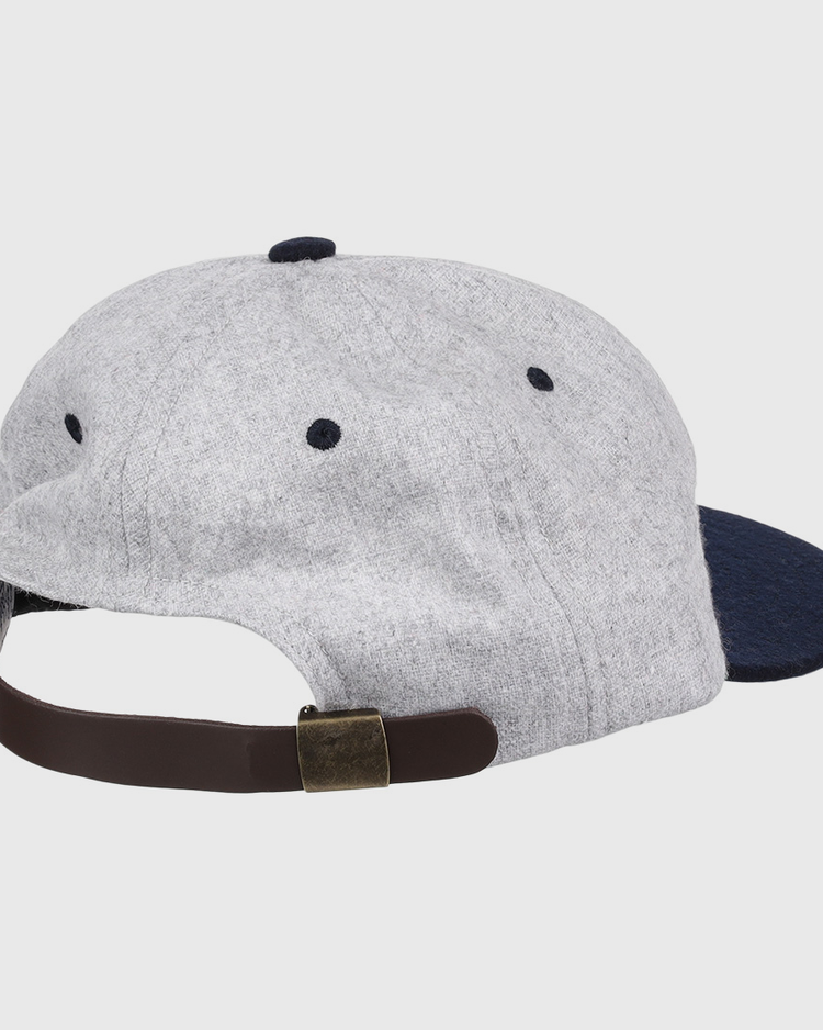 The EFF University of Nevada Wolf Pack Mascot Collegiate Wool Ballcap is shown from the back in grey and navy, featuring a brown adjustable strap with a brass-colored buckle. This is an officially licensed college vault item.