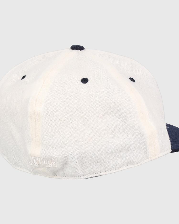 A white EFF University of Nevada Wolf Pack Mascot Collegiate Wool Ballcap with a navy blue button and brim, shown from the back on a white background. Features visible stitching and a small embroidered logo near the bottom edge.