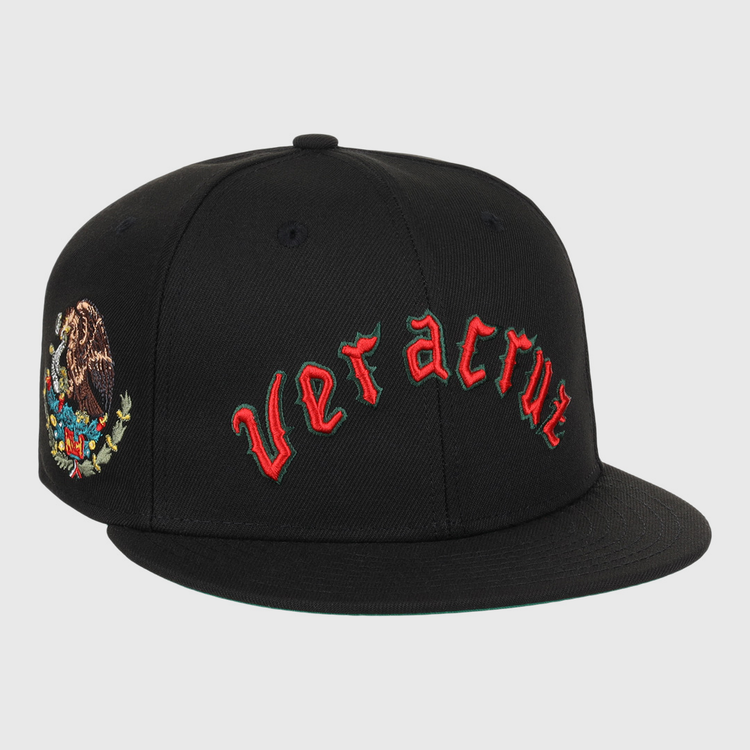 The EFF Veracruz Azules NLB Team Color Fitted Ballcap is a black hat with red gothic lettering on the front and the Mexican emblem on the side—ideal for fans wanting a vintage-inspired Mexican League style.