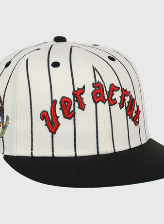 The Veracruz NLB Pinstripe Fitted Ballcap by EFF is a white cap with black pinstripes, a black brim, Veracruz in red gothic letters on the front, and an eagle-and-cactus embroidered patch on the side.