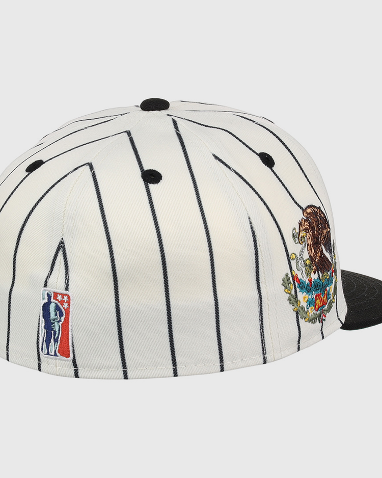 The EFF Veracruz NLB Pinstripe Fitted Ballcap is a white cap with thin black pinstripes, a black brim, a colorful bear and mountains patch on the side, and an embroidered NBA logo on the back.
